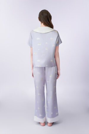 Back view of woman wearing Tinker Bell Moonglade Dream Silk Short-Sleeve Pajama Set with an all-over cloud-and-fairy print.