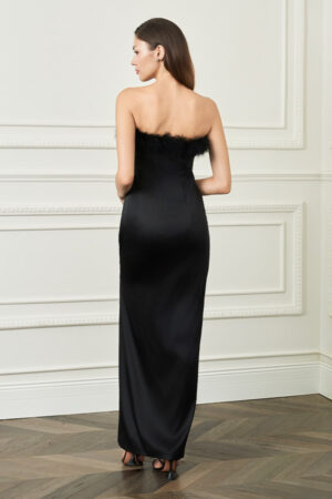 Back view of woman in black New Diva feather strapless dress, smooth satin column creating a clean, elongated silhouette.