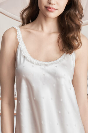 Close-up of woman wearing the Sweetie Silk Chemise, highlighting the lace-trimmed neckline and subtle heart jacquard detail.